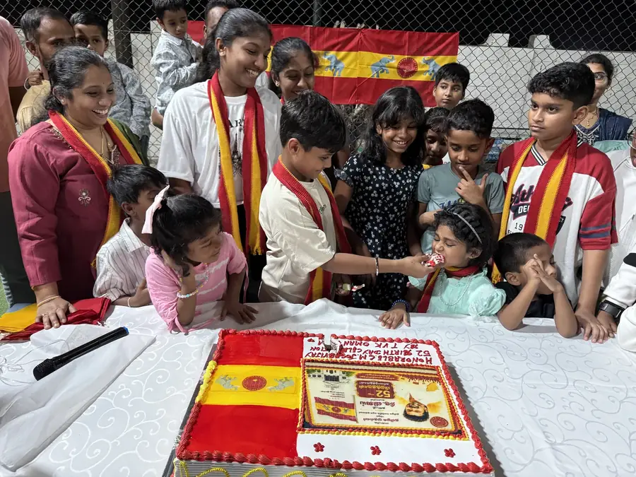 கேக் வெட்டும் நிகழ்வு — கழகச் சால்வையுடன் உறுப்பினர்கள் சூழ்ந்து நிற்கின்றனர்.